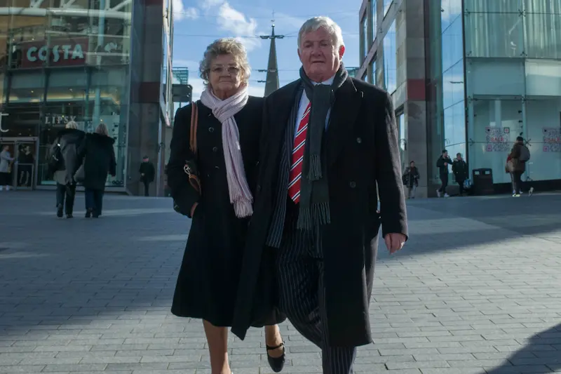 An old couples walking in city center