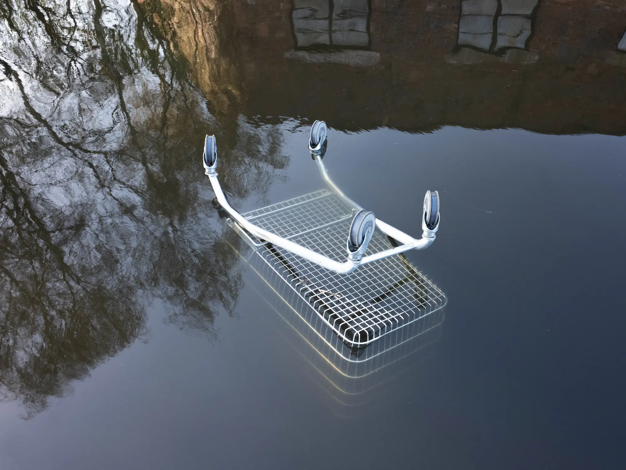 A shopping trolly is falling in the canal