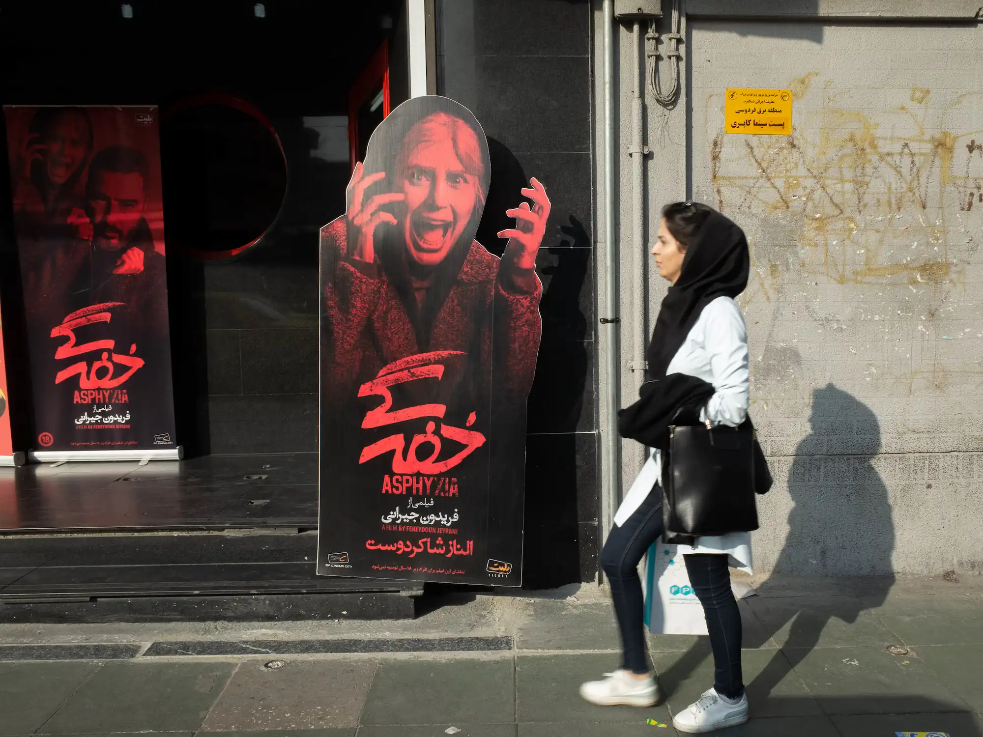 A woman passing by cinema