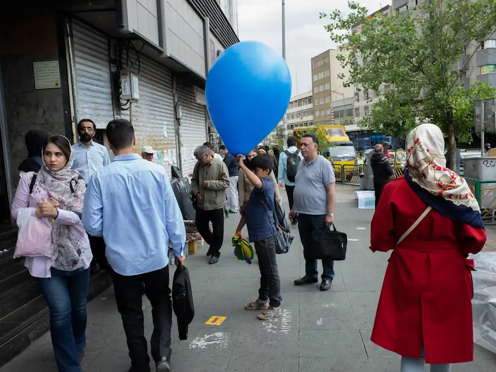 A boy selling ballon by the tube