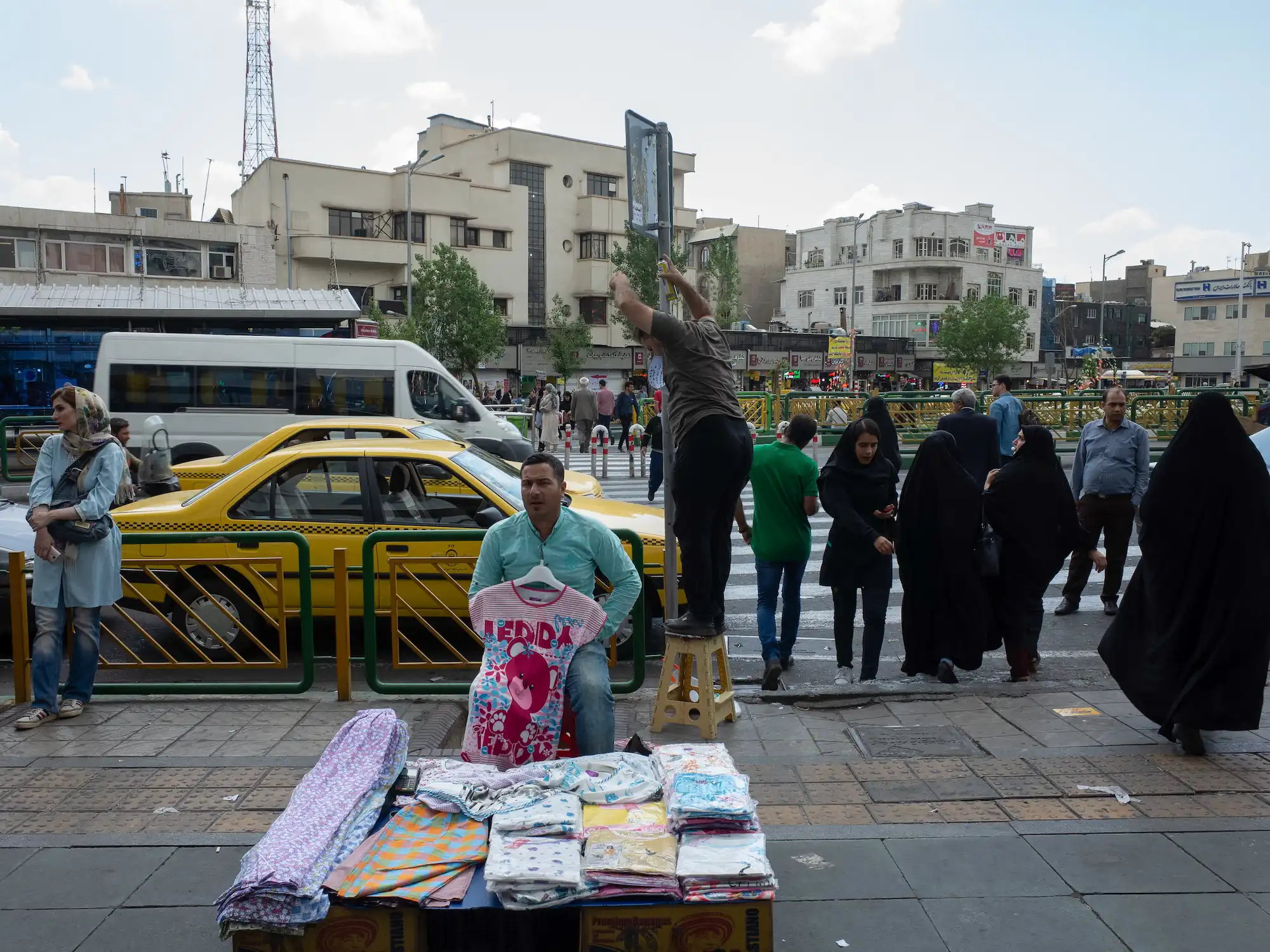 A man selling clothes in a sidewalk